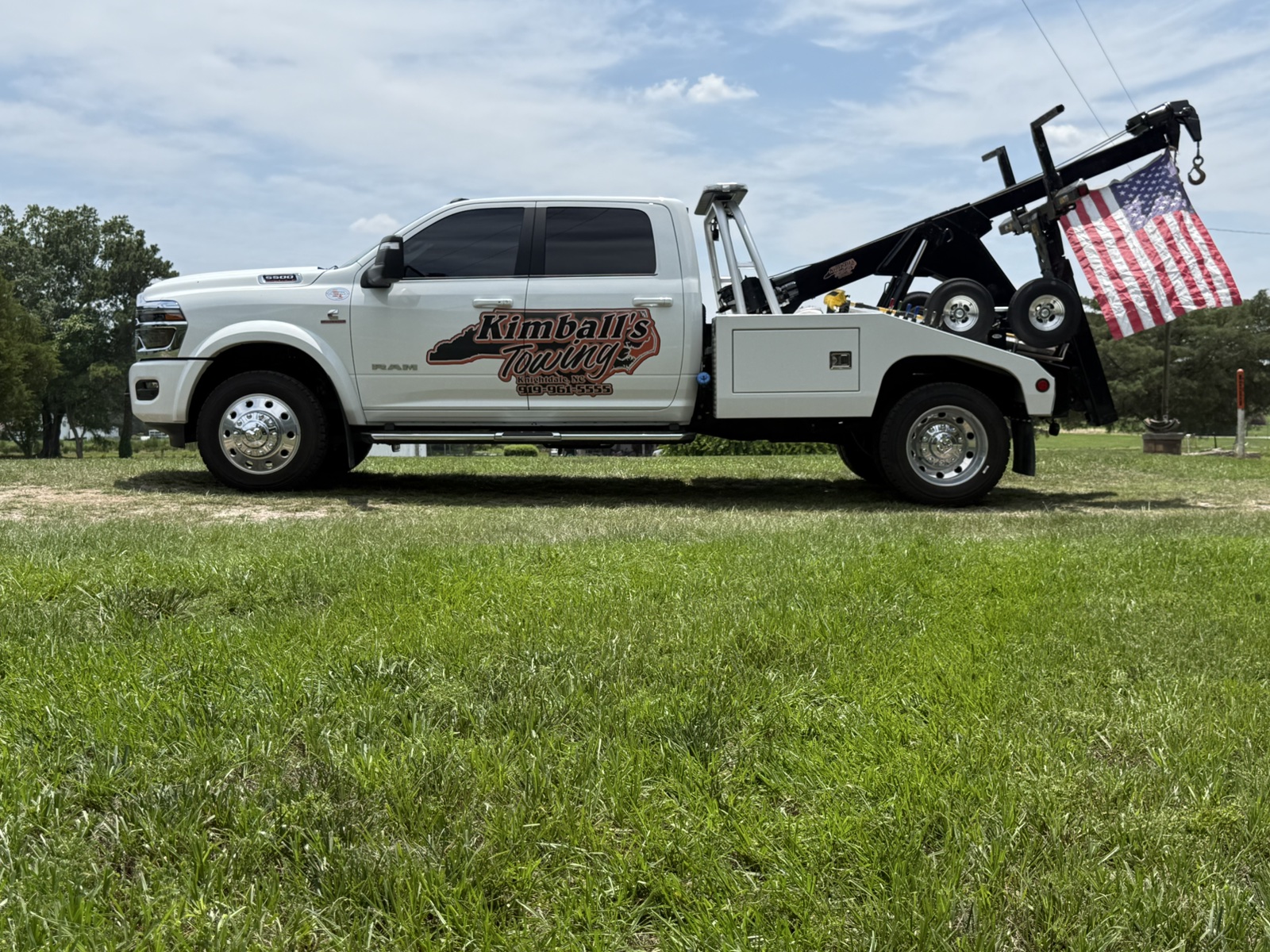 Kimball's Towing truck parked with a large American flag
